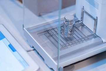 Stainless steel calibration weight to place on the analytical balance for calibration test.