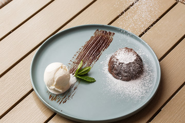 Delicious fresh fondant with hot chocolate and ice cream and mint served on plate. Lava cake...