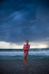 Fitness model on the beach at storm