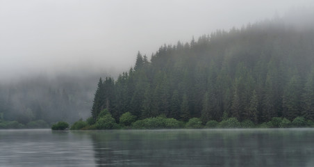 early morning mountains lake covered in fog 