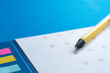 close up of calendar and pen on the blue background, planning for business meeting or travel planning concept