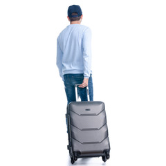 Man in jeans with travel suitcase goes walking on white background isolation, back view