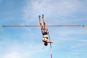 pole vault woman jumper on blue sky background in athletics