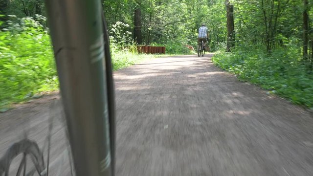 cycle rides along narrow path and follows amateur cycler