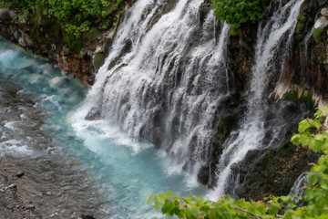 Fototapeta na wymiar Scenery of shirahige's waterfall and Biei river. The water of this river flows into the blue pond at the downstream. Biei Hokkaido, Japan