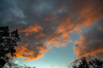 Fototapeta premium Multiple exposure of some clouds illuminated in yellow by the sunset light in the central Andean mountains of Colombia.