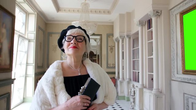 Elegant elderly woman visiting art gallery