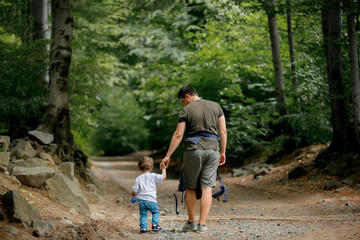 father and son walking along a path in the forest