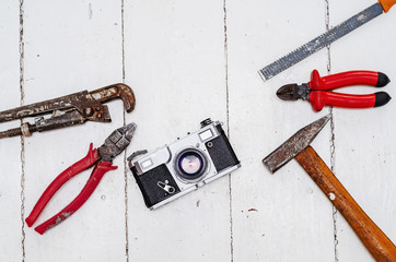 Composition of old tools, pliers, hammer, wrench, nippers and a vintage old film camera