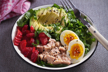 Tuna strawberry avocado egg and spinach salad in bowl - healthy food