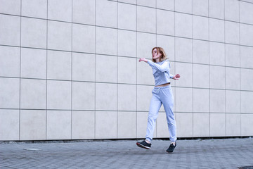 The girl is blonde in a gray sports suit. Street clothing. Sport. Advertising. Fashion and style. Trends. Mockup. Copyspace