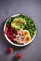 Tuna strawberry avocado egg and spinach salad in bowl - healthy food