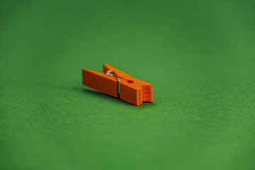 orange plastic clothespins on a green background.