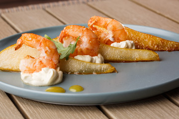 Grilled tiger shrimps with honey rear and cream cheese. Grilled seafood. On wooden background.