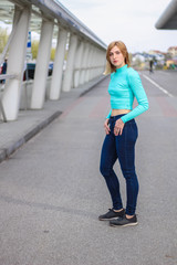 The girl is blonde in a blue croptop. Street clothing. Sport. Advertising. Fashion and style. Copyspace. Mockup