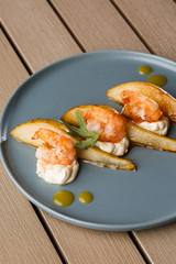 Grilled tiger shrimps with honey rear and cream cheese. Grilled seafood. On wooden background.