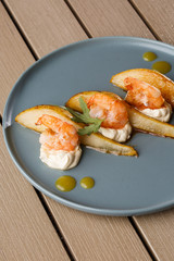 Grilled tiger shrimps with honey rear and cream cheese. Grilled seafood. On wooden background.