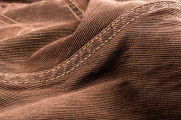 clothing items stonewashed cotton fabric texture with seams, clasps, buttons and rivets, macro