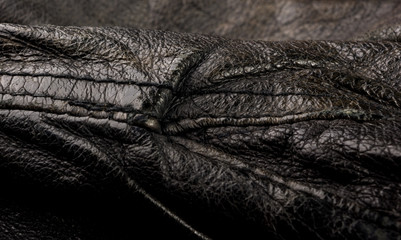Old vintage genuine soft black leather texture background, top layer with pores and scratches, macro, close-up