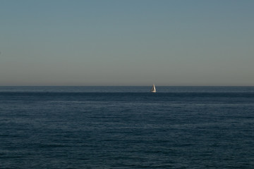 Obraz premium Sailing boat in the distance to the sea in the evening
