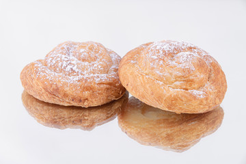A couple of rolls of freshly baked puff pastry with powdered sugar on top