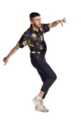 Full-length portrait of a funny guy dancing in studio isolated on white background.