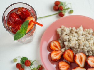 oatmeal with strawberries and strawberry lemonade on the white table