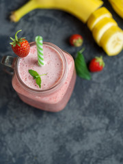 Strawberry smoothie with banana or strawberry milkshake in a glass jar with copyspace