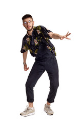 Full-length portrait of a funny guy dancing in studio isolated on white background.
