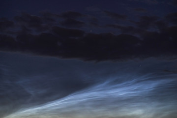 Fototapeta na wymiar Noctilucent clouds closeup summer night.