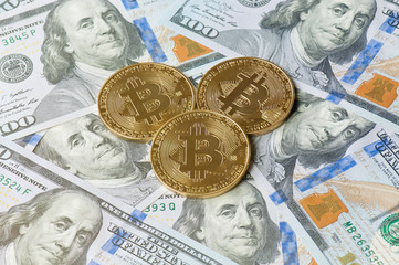 Golden bitcoin coins on US hundred dollar bills background. Electronic money exchange. Virtual money and digital crypto currency concept.