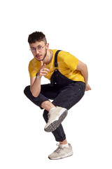 Full-length portrait of a funny guy dancing in studio isolated on white background.