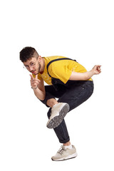 Full-length portrait of a funny guy dancing in studio isolated on white background.
