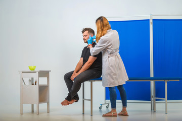 The man on the couch in the doctor's office. Mesotherapy for a young guy. Injections with a syringe...