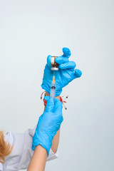 Woman doctor fills syringe with medicine. Procedures in the medical office. Nurse's hands in blue...