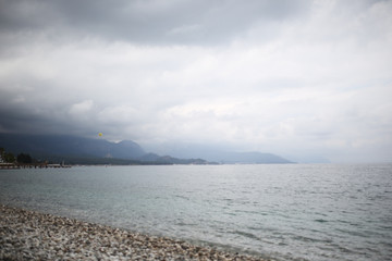 sea and mountains, pebble beach in cloudy weather