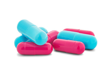 Pile of medical pills in red and blue colors on white isolated background with shadow.