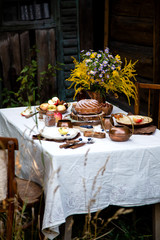 beautiful outdoor still life in country garden with bundt cake on wooden stand on rustic table