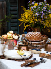 beautiful outdoor still life in country garden with bundt cake on wooden stand on rustic table