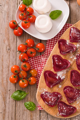 Red heart ravioli with tomato, mozzarella and basil. 