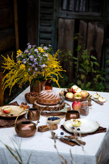 beautiful outdoor still life in country garden with bundt cake on wooden stand on rustic table