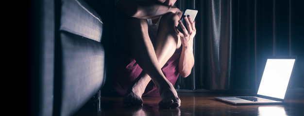 Man sit on floor use smartphone and laptop suffering from derpression disorder, conceptual of...