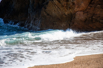 Ocean wave near beach rock