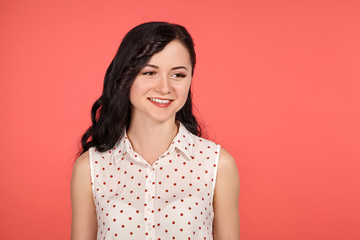 Studio shot of a beautiful girl teenager posing over a pink background.