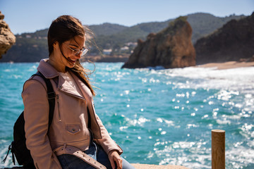 Beautiful woman portrait on the shore with blurred background waves and rocks