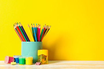 Obraz premium School supplies on wooden table against color background, space for text