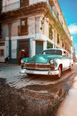 Poster Antieke auto met reflecties op een waterplas in Oud Havana © kmiragaya