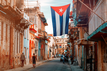 Cuban flags, people and aged buildings in Old Havana