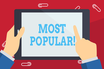Writing note showing Most Popular. Business concept for defined as liked or enjoyed by analysisy showing in particular place Businessman Hand Holding and Pointing Colorful Tablet Screen