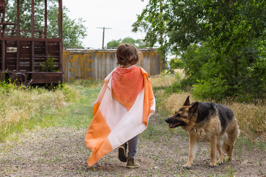 5 year old boy wearing a cape in rural location